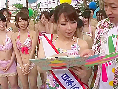 Naughty Japanese babes are kneeling in front of a guy with a hard- on and sucking his cock