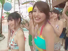 Naughty Japanese babes are kneeling in front of a guy with a hard- on and sucking his cock